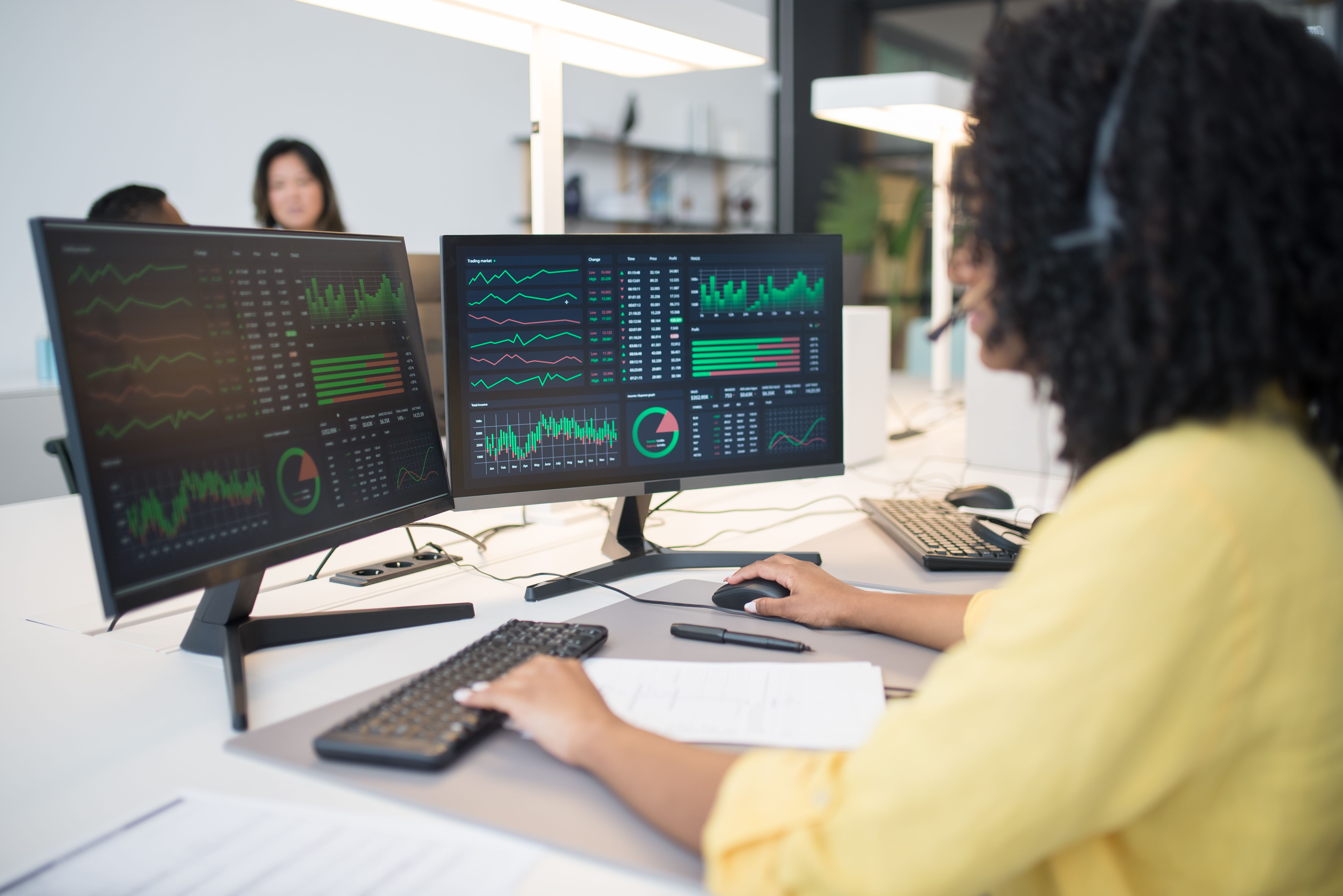 Professional working at dual monitors in a modern office